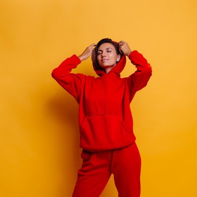 mulher usando conjunto de moletom vermelho em fundo amarelo