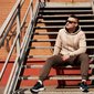 homem sentado em escada com look casual masculino